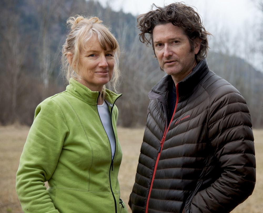 Portrait of the artists Janet Cardiff and George Bures Miller, standing in front of an open field