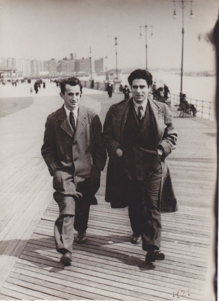 Black and white photo of Chaim Gross and a friend. The two are dressed in suits and smiling, walking down the boardwalk of Coney Island.