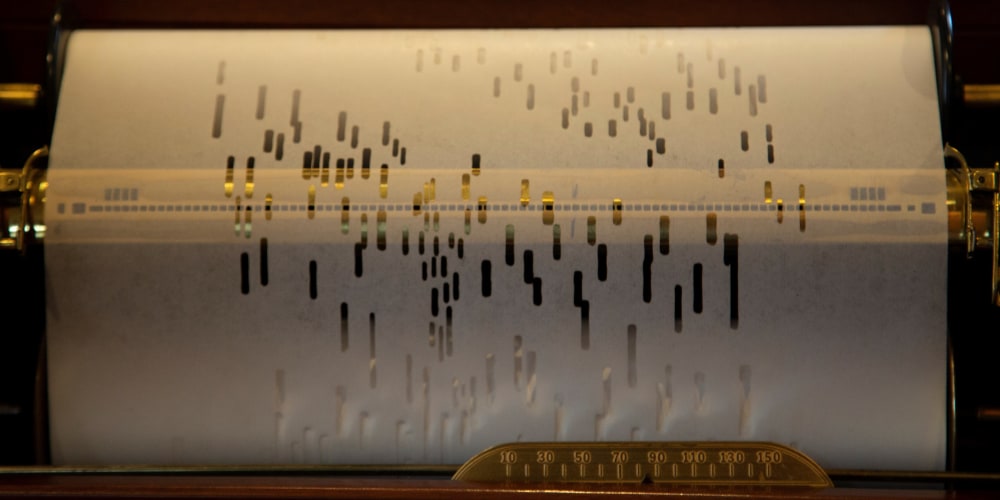 close-up view of player piano roll scrolling through a player piano