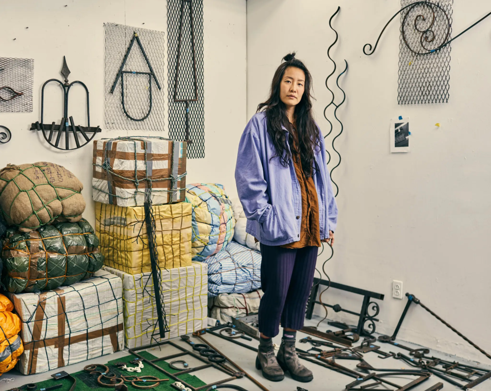 Ms. Lee’s studio in Gowanus, Brooklyn, with welded symbols, and burlap “luggage.”Credit...Christopher Gregory for The New York Times