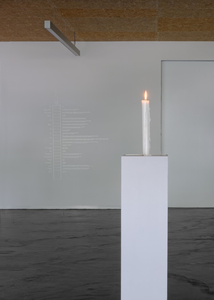 a lit candle standing on a column