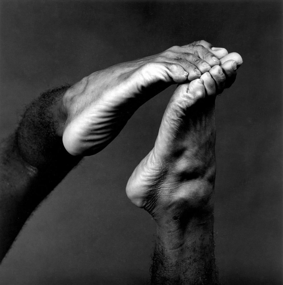 Two feet touching at the toes.
