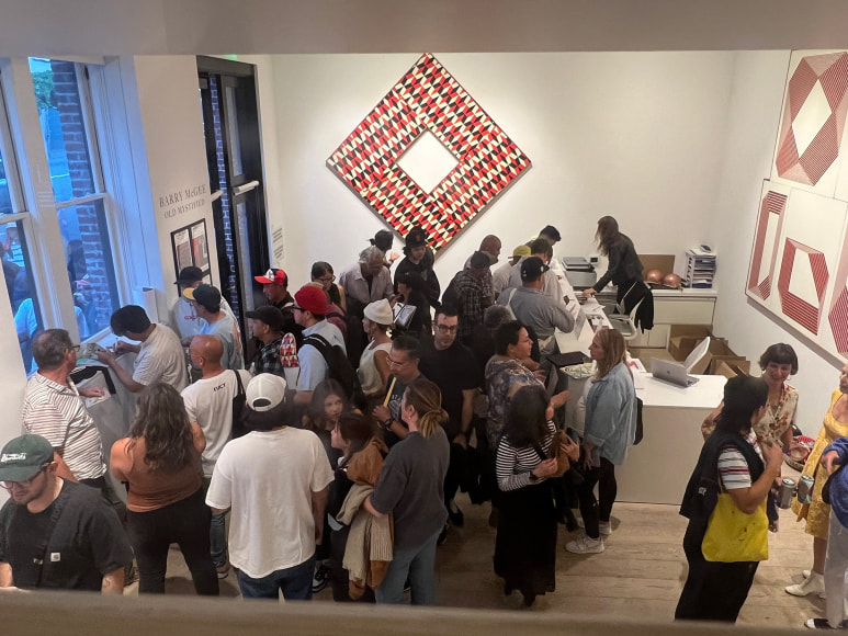 Barry McGee, at left, signs books for fans at the opening reception for Barry McGee: Old Mystified&nbsp;on September 27, 2024.