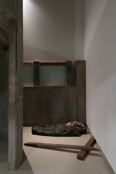 Installation view of Mike Nelson, Untitled (Public Sculpture for a Redundant Space), 2016. Sleeping bag, rubble, concrete.. Photo: Matt Greenwood., Courtesy the artist and the Hayward Gallery.