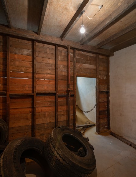Installation view of Mike Nelson, Triple Bluff Canyon (the woodshed), 2004. Various materials. M25, 2023., Found tyres. Photo: Matt Greenwood. Courtesy the artist and the Hayward Gallery.