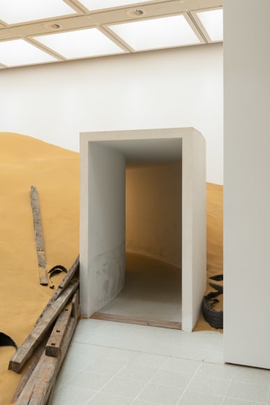 Installation view of Mike Nelson, Triple Bluff Canyon (the woodshed), 2004. Various materials. M25, 2023., Found tyres. Photo: Matt Greenwood. Courtesy the artist and the Hayward Gallery.
