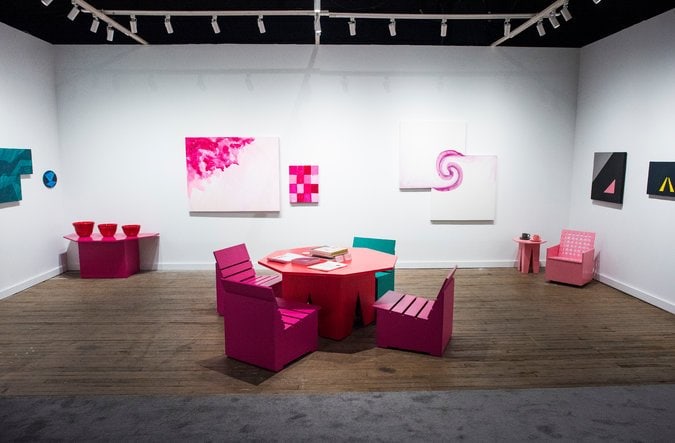 At the booth of the 303 Gallery, a solo exhibition of new and older works by Mary Heilmann includes paintings, glazed ceramics and an arrangement of furniture. Credit: Joshua Bright for The New York Times