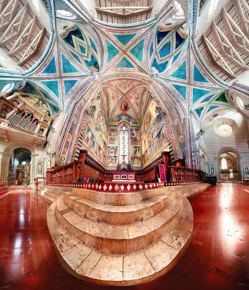 Panoramic composite color photo of the ornate interior of an Italian cathedral.