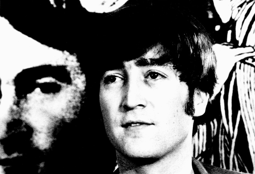 Black and white image from a Beatles press conference in 1966. Close-up of John Lennon.