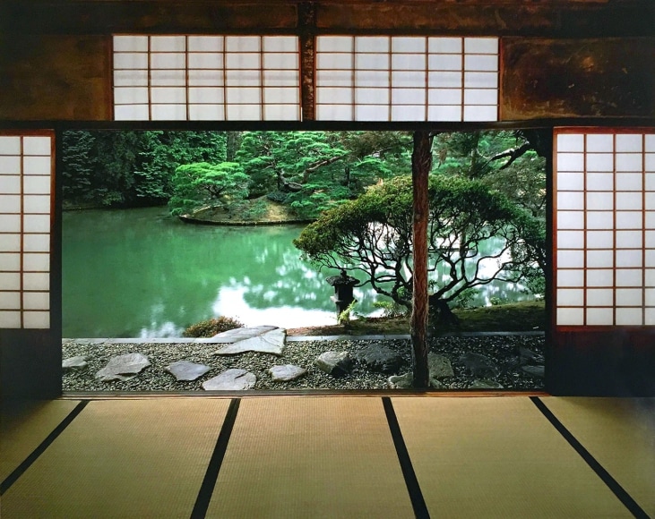 Color photo of a view of a Japanse garden and pond, looking out from the interior of a traditional Japanese villa.