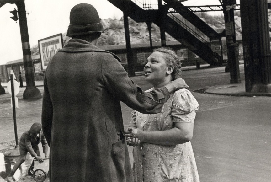 Black and white photo of a woman comforting another woman under an elevated train Laine in NYC.