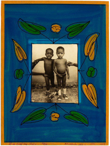 Black and white photo of two young African boys, one crying, in a hand painted floral frame
