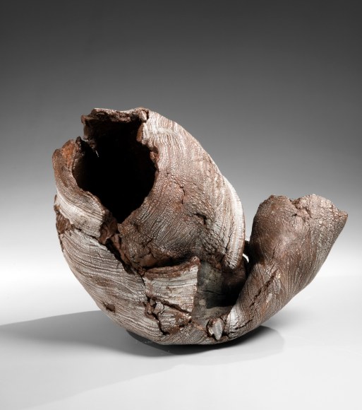 Torn open globular sculpture, coated with liquid white slip