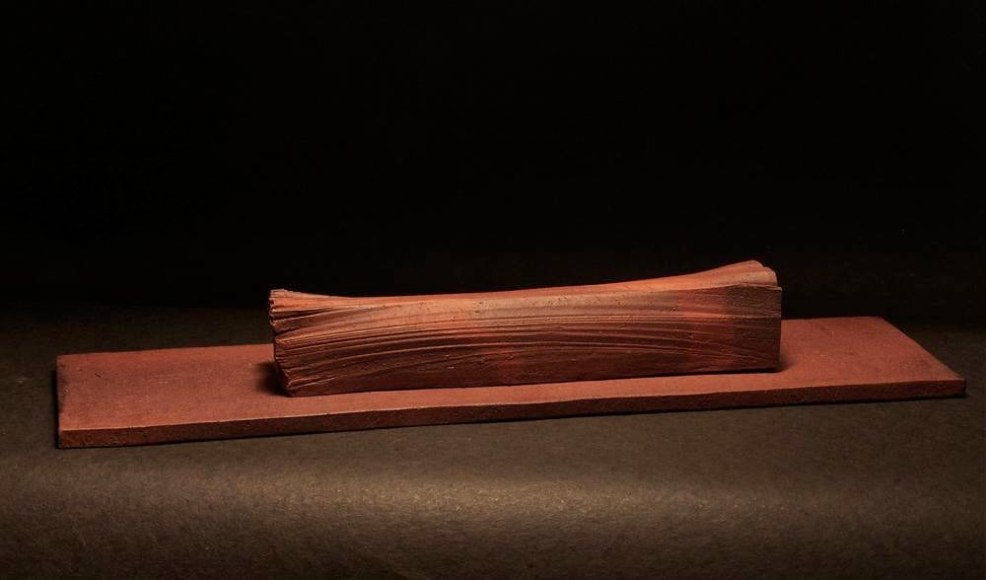 Rectangular sculpted vessel rests on a flat base, titled TAIRAGI +, 2012