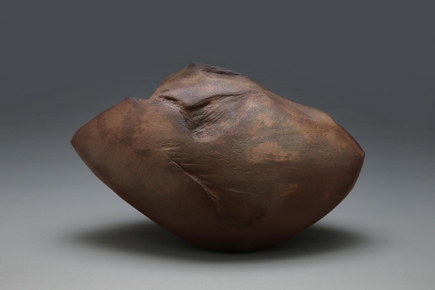 Horizontal, scooped-out, diamond-shaped sculptural vessel with rounded body, jagged rim and Hagi kohiki glaze in naturalistic tones of brown, gray and rust, 2014