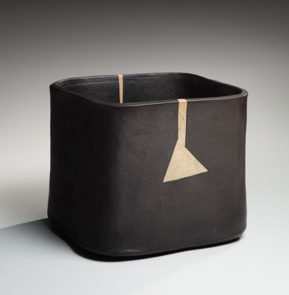 Slightly rounded open square vessel with white asymmetrical triangular design and matte brownish-black overglaze
