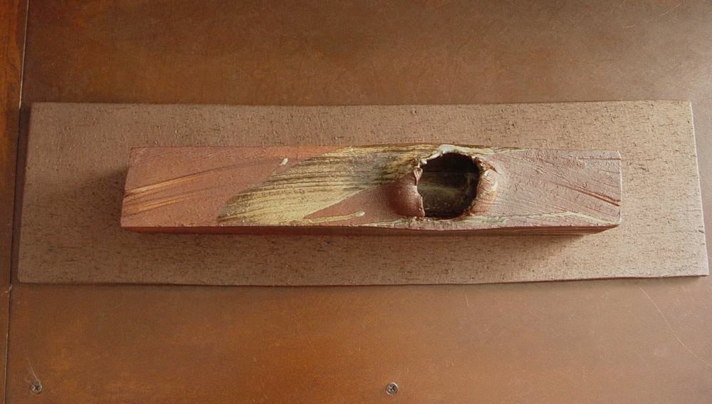 Rectangular sculpted container rests on a flat base, titled TAIRAGI, 2010