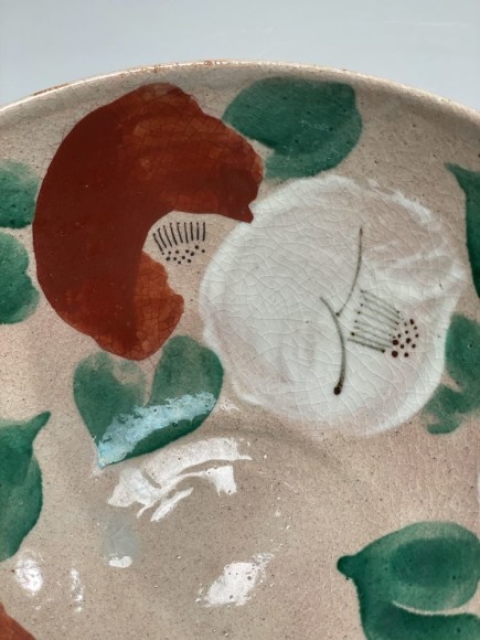 Bowl decorated with red and white camellias with bright green leaves