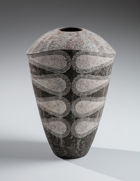 Multi-fired broad-shouldered charcoal gray vessel with tapering narrow base