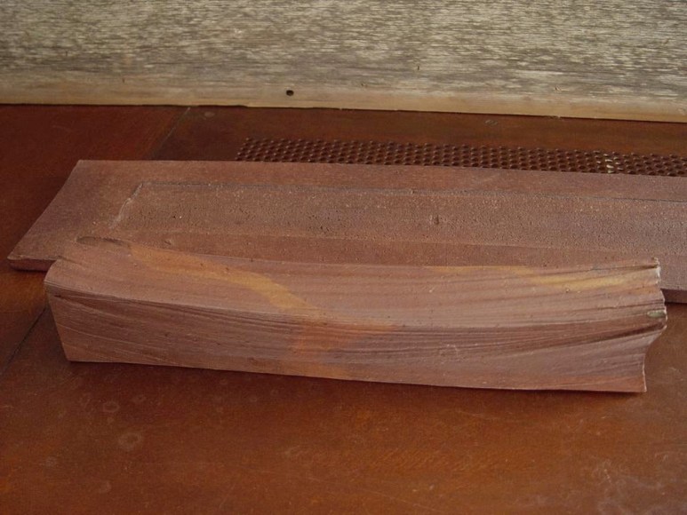 Rectangular sculpted vessel rests on a flat base, titled TAIRAGI +, 2012