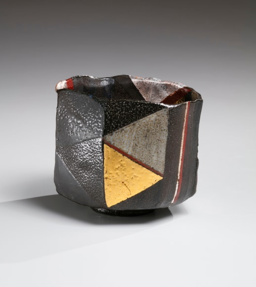 Black basara faceted, irregular teabowl with vertical panels of colored salt glazing with gold and silver-leaf