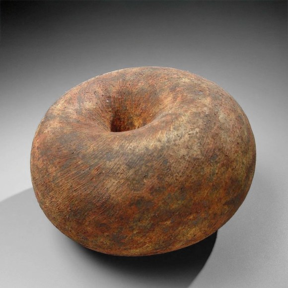 Round sculpture with concave center and rough texture of deep red and black slip glaze, 2007