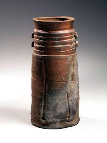 Large unglazed cylindrical vase with carved bands at the shoulder and two vertical pairs of circular knobs with a thick flaring mouth