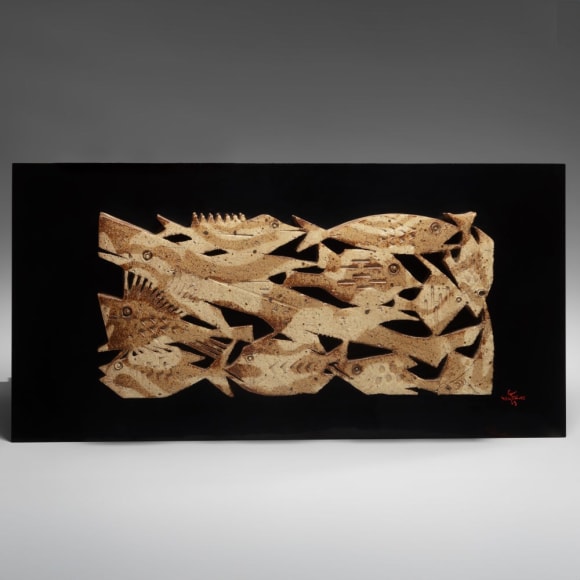 Hanging, sculpted and carved plaque depicting a school of fish in marbelized clay