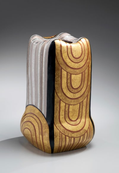Columnar standing vessel with raised lobed mouth and bulbous base;&nbsp; linear and half-circular patterning in red, black, gold and silver glazes