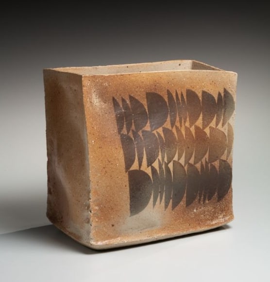 Thinly glazed open, irregular, rectangular vessel with horizontal rows of half-moon patterning in iron-oxide glaze