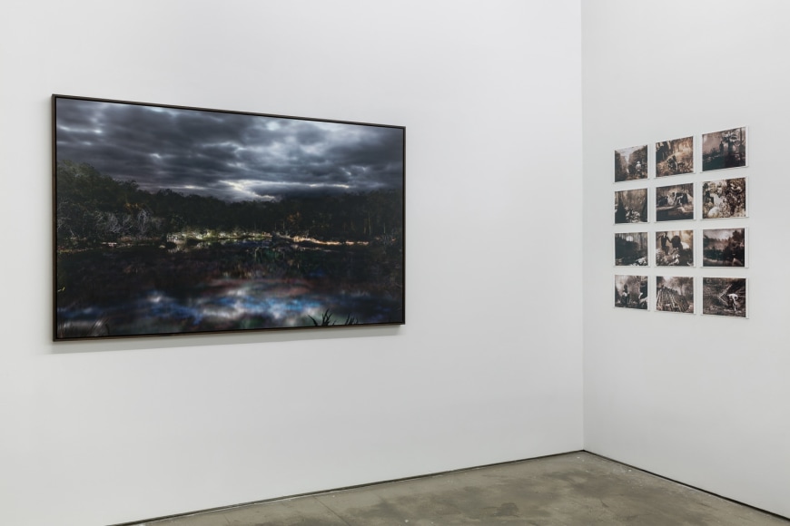 An installation view of Jasper de Beijer's exhibition, "The Brazilian Suitcase". Framed photographs are on the walls. Small pieces are arranged in a grid.