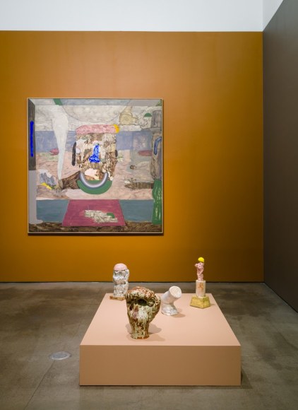 An installation view of paintings and sculptures by Gudmundur Thoroddsen. Large and medium paintings are hung on the wall by ceramic sculptures on pedestals.