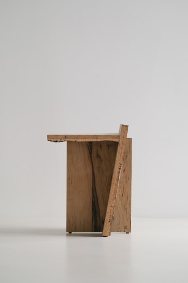 Side table made of oak and cork with a slant and photographed on grey background.