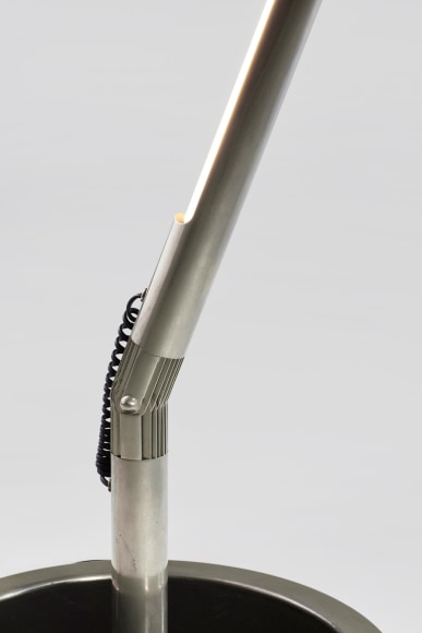 photograph of long metal floor lamp in a blank room