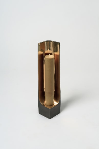 Bronze candlestick with gold detailing and black exterior.