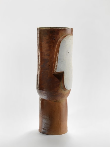 photograph of a cylindrical vase in an empty room