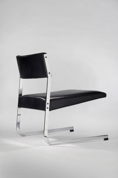 Back view of low steel framed lounge chair with black leather upholstery
