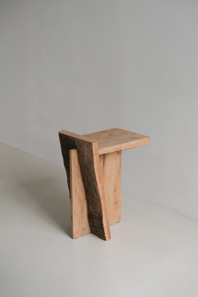 Side table made of oak and cork with a slant and photographed on grey background.