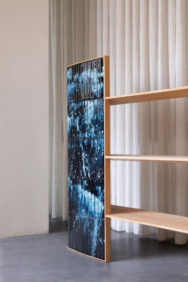 wooden bookshelf with blue panels in a room