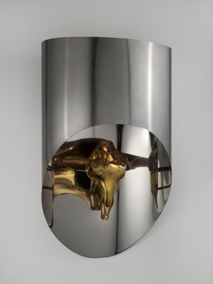 Stainless steel sconce with bronze animal skull on white wall