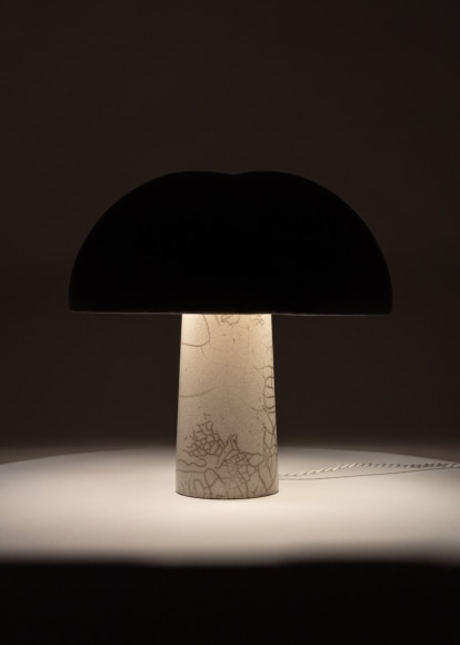 Illuminated lamp with a matte black glazed shade and white raku glazed base