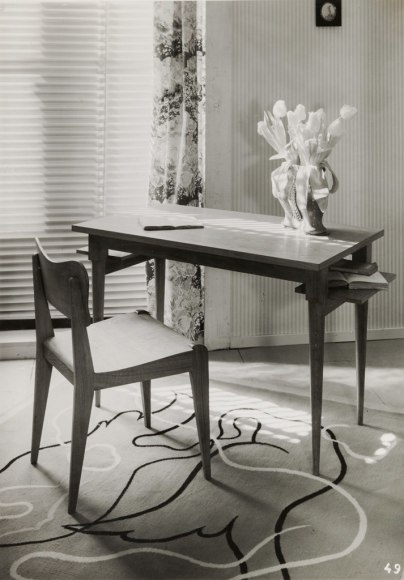 black and white archival image of the chair made by Dumond sitting in front of a desk.