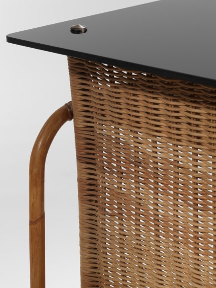 rattan desk in an empty room