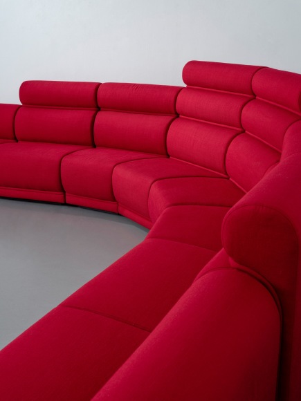 Red long huge sofa upholstered photo shots in a studio. Sofa is by Pierre Paulin.