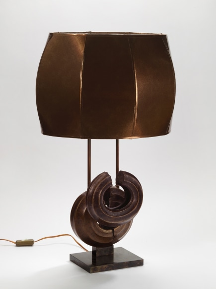 photograph of a brown lamp in a white room with two overlapping circles at its base