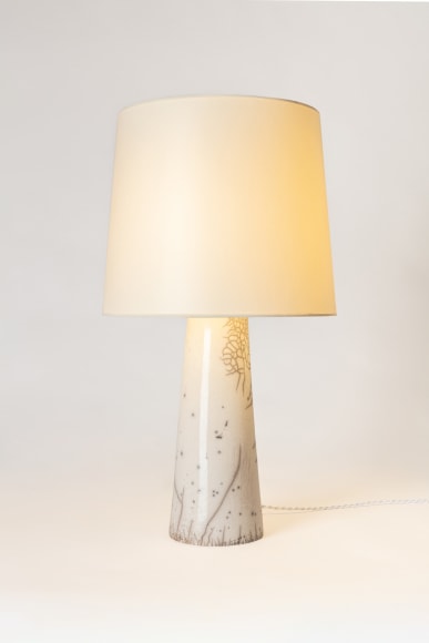 Raku lamp in a classic form with a white speckle and a white fabric shade. light is illuminated