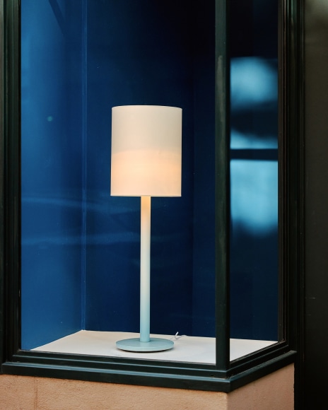 Installation view of works in the gallery, mostly furniture and some rugs and art. Lamp in blue cove.