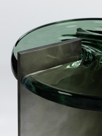 Madonna side table in aluminum and glass against a plain white background.