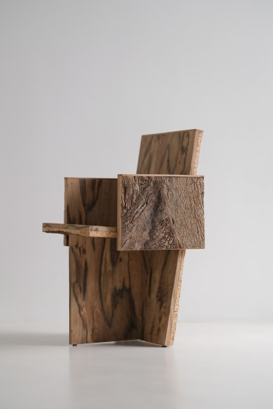 Wood and cork chair with arms and different angles photographed with a grey background.
