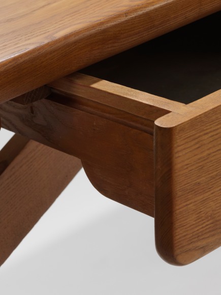 photograph of a wood desk in a blank room